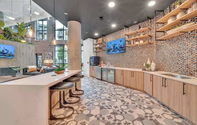 a kitchen with a long counter and stools in a lobby