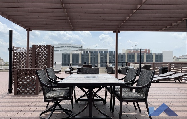 a table and chairs on a roof terrace with a view of the city