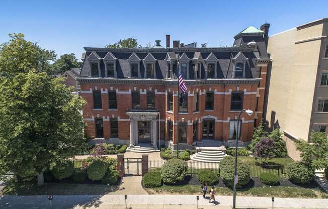 an aerial view of a brick building with an flag at The Knights @ 506 Delaware Apartments, New York, 14202