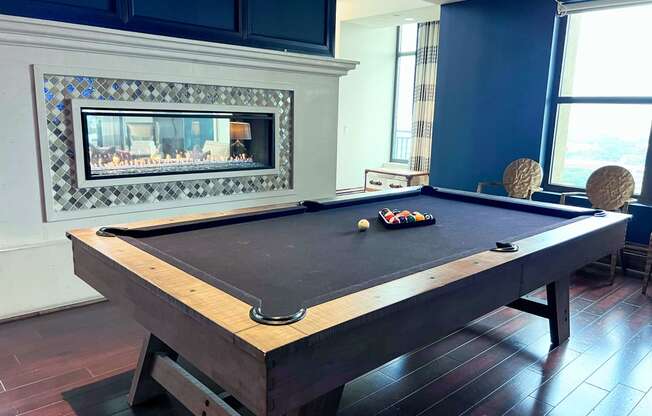 a pool table in a living room with a fireplace