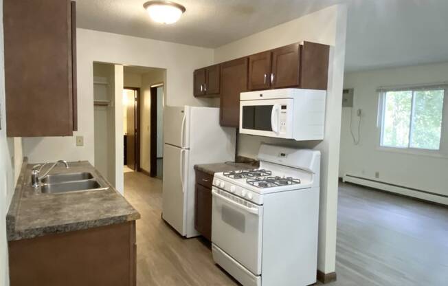 a kitchen with white appliances and brown cabinets