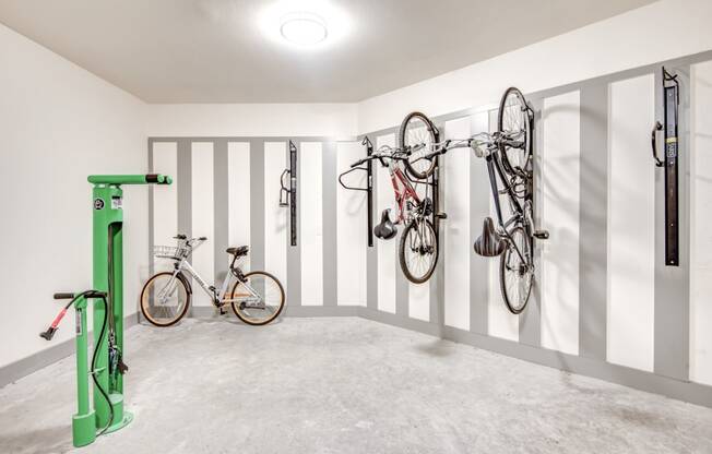 two bikes hanging on the wall in a room with white walls