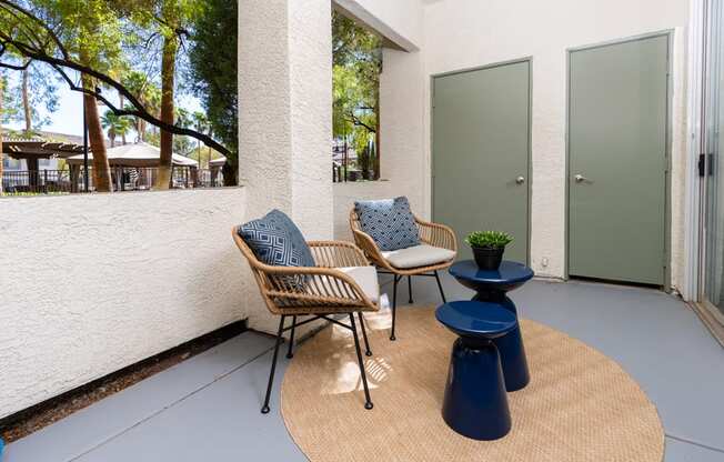 a patio with two chairs and a table and a door