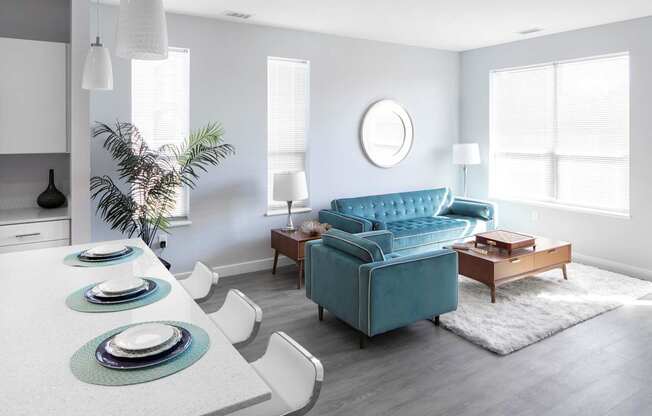 a living room with a blue couch and a table and chairs