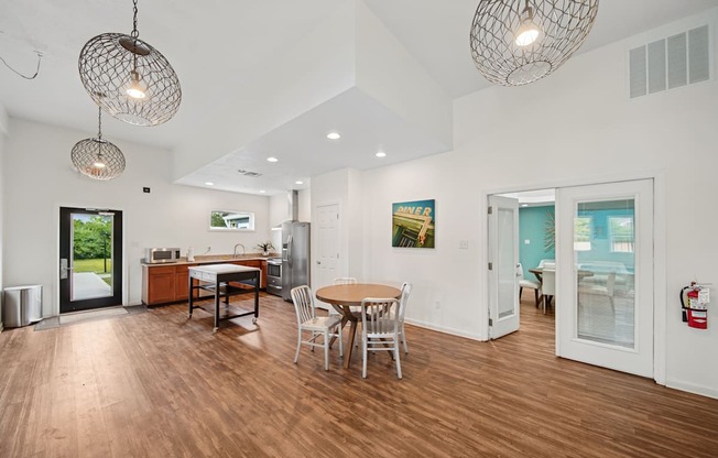 A modern open plan living and dining room with wooden floors and white walls.