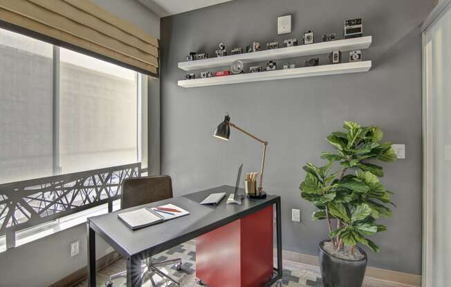 a home office with a desk and a plant