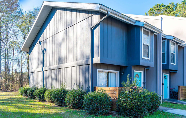 A blue house with a white door and windows.