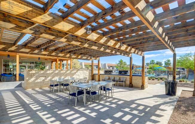 a patio with tables and chairs and a pergola