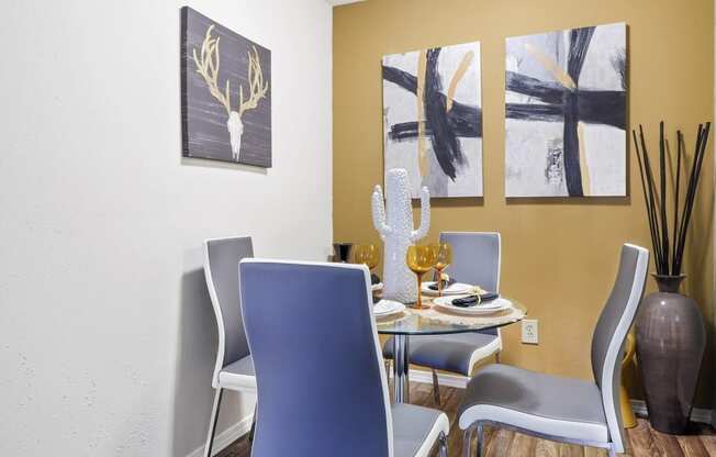 a dining room with a table and chairs and paintings on the wall