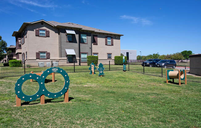 A green sign with two circles on it is in front of a building.
