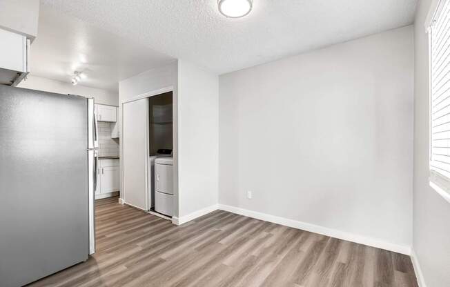 A kitchen with a refrigerator and a washing machine.
