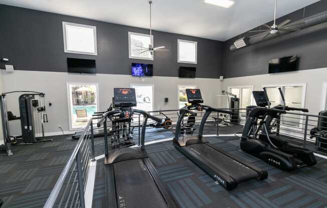 a gym with cardio equipment and windows in a building  at Deerfield Village, Alpharetta