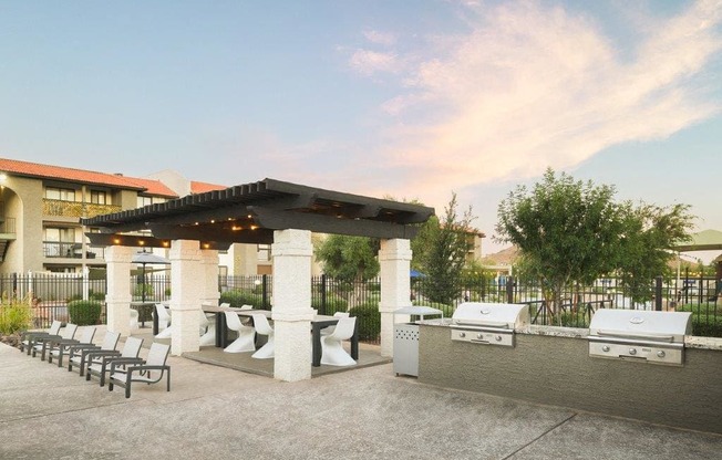 a patio with a grill and tables and chairs