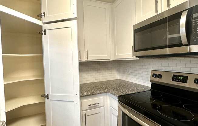 a kitchen with white cabinets and a black stove