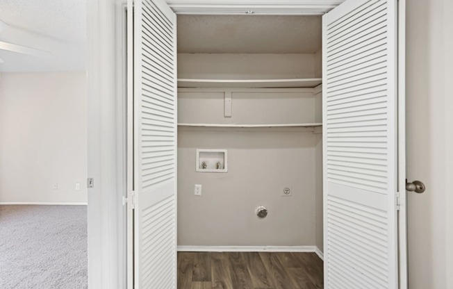 a bedroom with a medium sized closet and hardwood floors