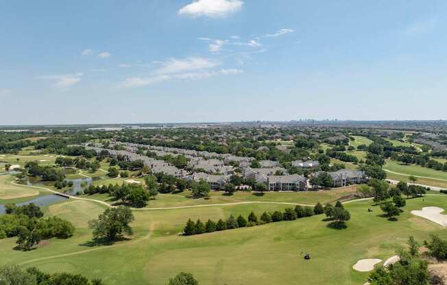 A golf course with a green field and a lake.