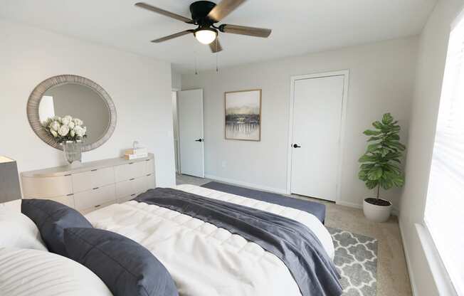 a bedroom with a bed and a ceiling fan