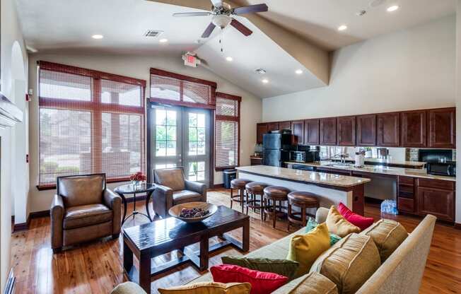 a large living room with a kitchen and a ceiling fan