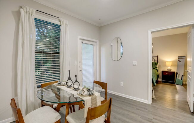 A dining room with a glass table and chairs.