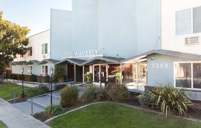 the facade of the walnut building with a lawn and gardens