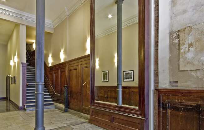 the lobby of a building with a large mirror and a staircase