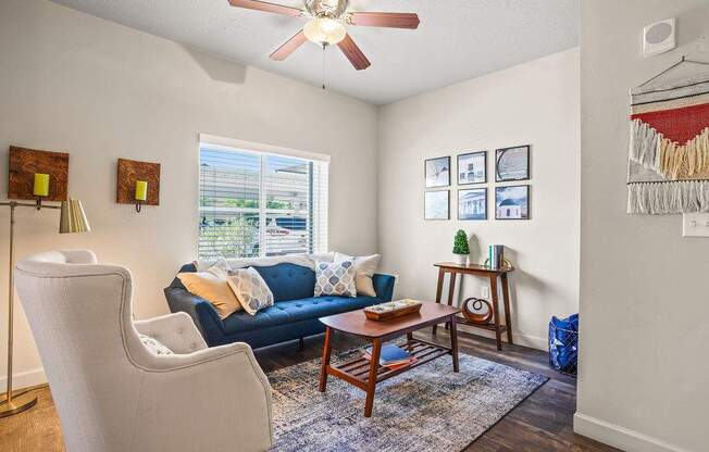 A living room with a blue couch and a white chair.