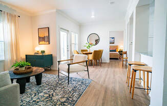 a living room and dining room with a table and chairs