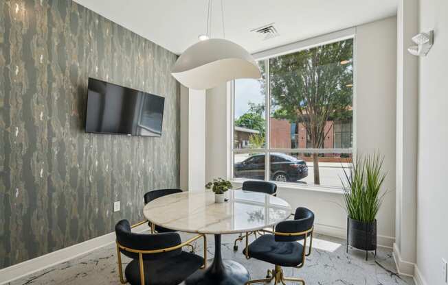 a dining room with a large window and a table and chairs
