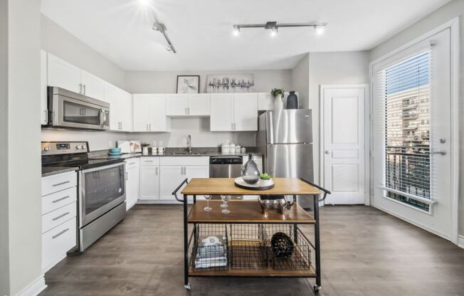 A kitchen with a table and a refrigerator.