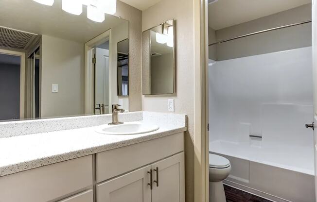 A bathroom with a sink, mirror, and toilet.