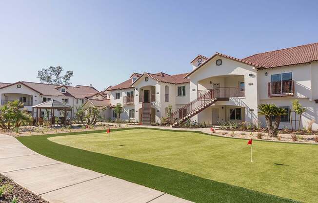 A row of houses with a green lawn in front.