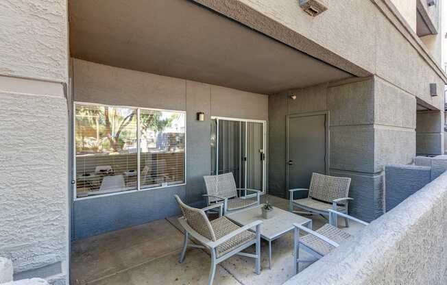 A patio with a table and chairs is on the balcony of a building.