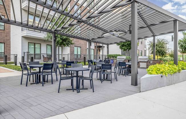 a patio with tables and chairs under awning