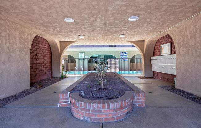 a courtyard with a fire place and a pool in the background