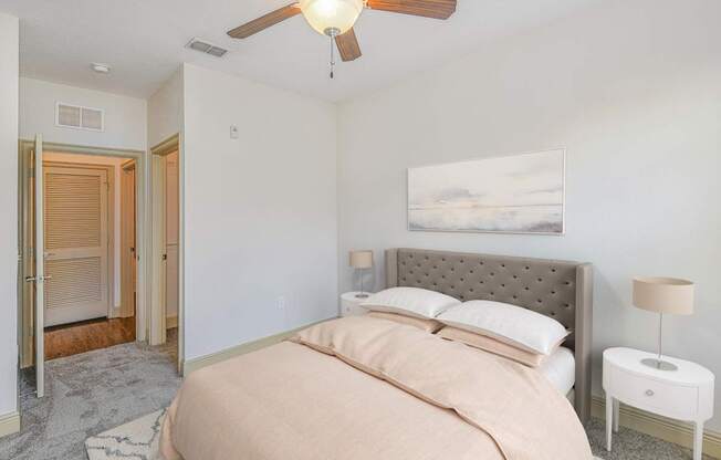 a bedroom with a bed and a ceiling fan