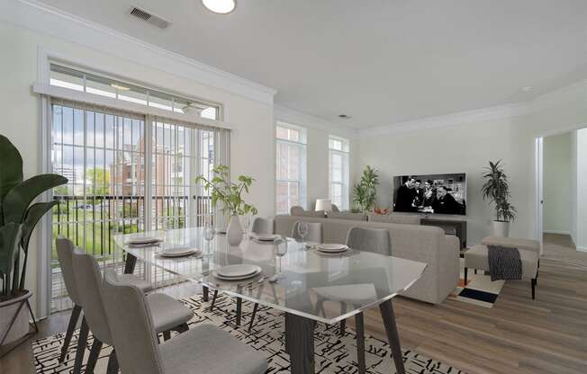 a living room with a glass table and a couch and a tv