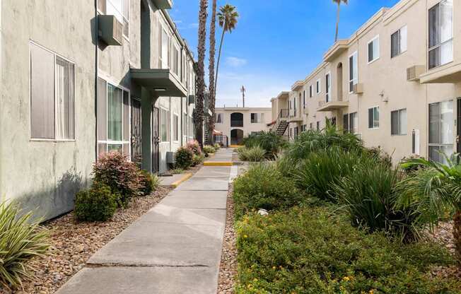 A row of houses with a concrete walkway between them.