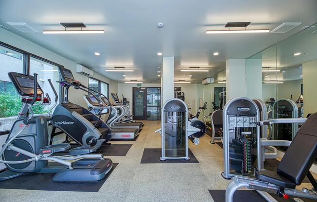 Fitness center with cardio machines, strength stations, and direct access to the pool deck.