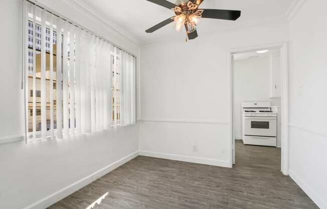 a living room with white walls and a ceiling fan