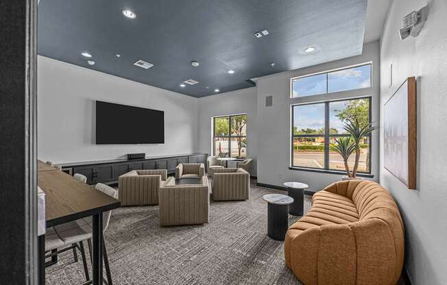 A room with a large window, a flat screen TV, and a comfortable seating area.