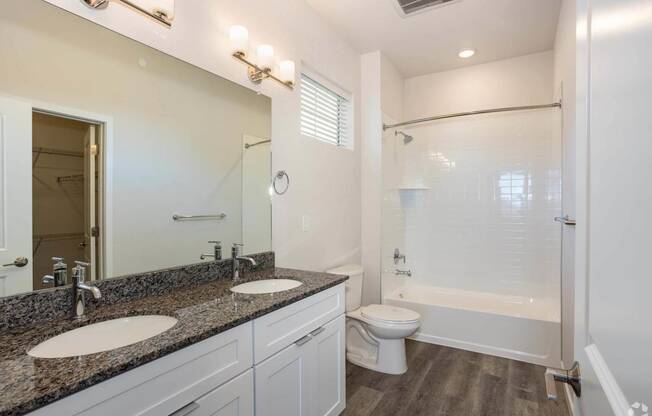 dual vanity bathroom with toilet and white tub at Palisade Park Townhomes, Colorado, 80023