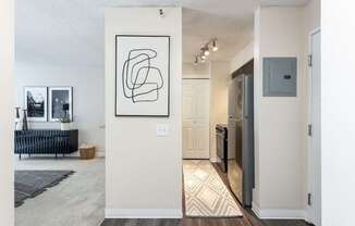 an open living room and kitchen with a refrigerator and a sink