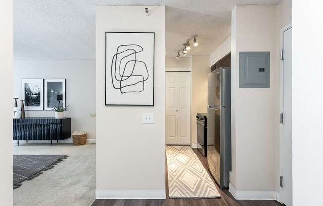 an open living room and kitchen with a refrigerator and a sink