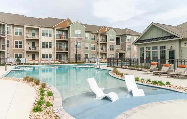 a swimming pool with lounge chairs and a building in the background at The Whitworth, Virginia