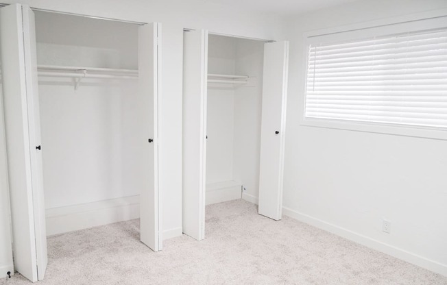 a bedroom with two closets and a window