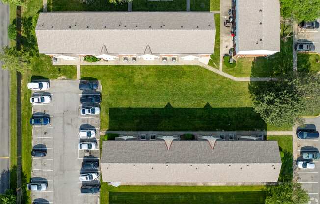 an aerial view of a parking lot and a building with cars parked
