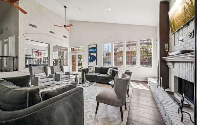 A living room with grey couches and a fireplace.