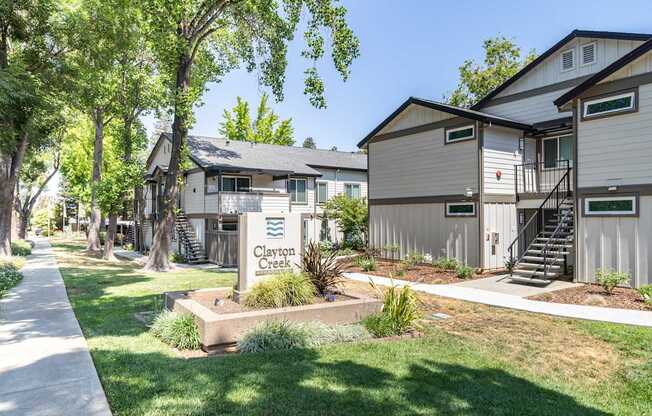 A row of houses with the name Clayton Creek on a sign in front.