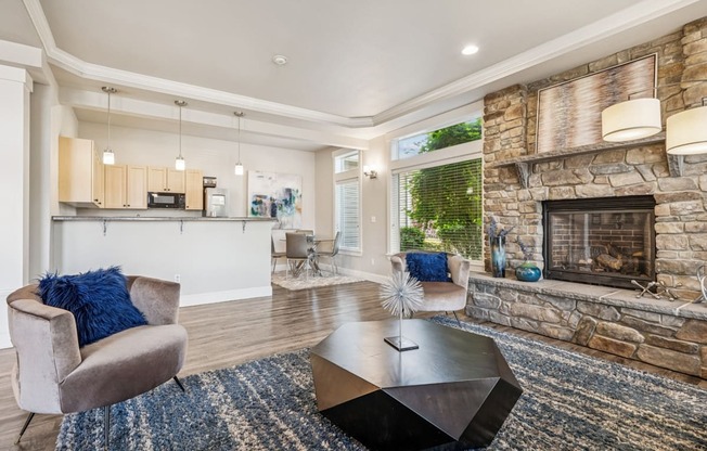 Clubhouse with a stone fireplace, kitchen, and seating at The Madison apartments in Olympia, WA