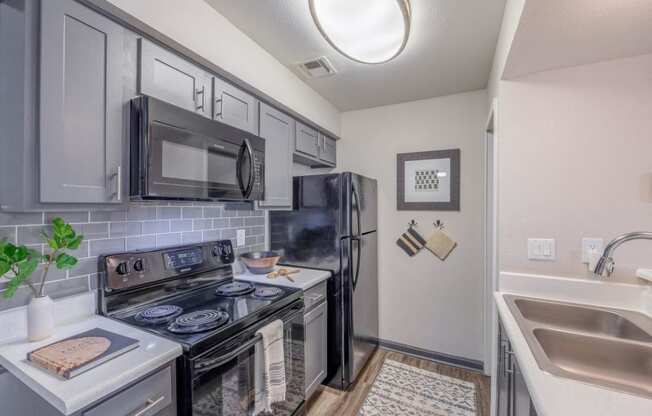 a kitchen with stainless steel appliances and a black refrigerator